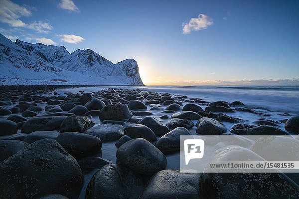 The sun is setting behind Helligberget peak at Unstad Beach. Vestvagoy municipality Nordland county Northern Norway Norway.