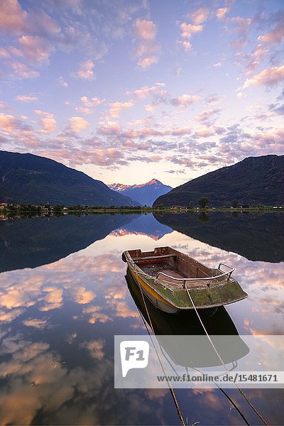 Boat moored in lake of Novate Mezzola at sunrise Valchiavenna Sondrio province Valtellina Lombardy Italy.