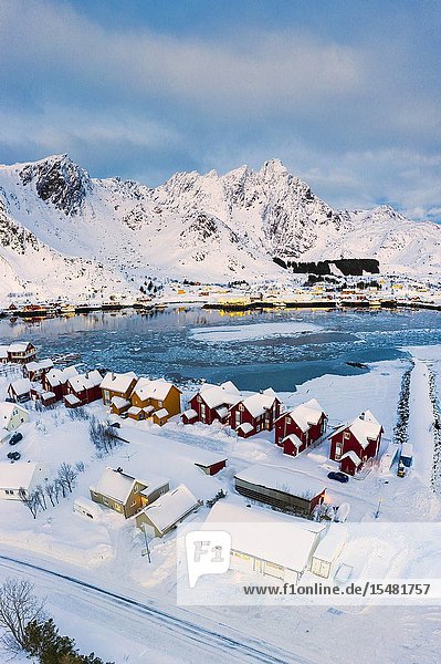Aerial panoramic of traditional Rorbu overlooking the frozen sea Ballstad Vestvagoy Lofoten Islands Norway.