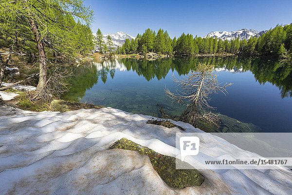 Snow on the shore of Lago Azzurro during spring Motta Madesimo Valle Spluga Valtellina Sondrio province Lombardy Italy.