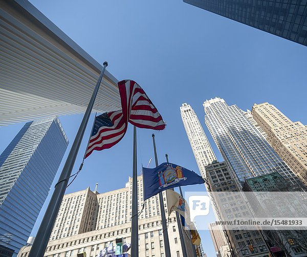 An American flag along with state city and governmental agency flags are whipped around by the wind outside of the World Trade Center Transportation Hub in Lower Manhattan in New York on Wednesday April 3 2019. (© Richard B. Levine).