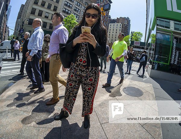 A distracted millennial engrossed in her smartphone in New York on Wednesday May 8 2019. (© Richard B. Levine).