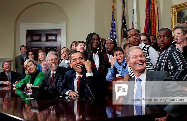 President Barack Obama is joined by members of Congress and school children as he talks March 24 2009 with astronauts on the International Space Station from the Roosevelt Room at the White House. Others seated include Sen. Kay Bailey Hutchison (R-Texas) left John Holdren second eft Director of the Office of Science and Technology Policy and Sen. Bill Nelson (D.-Fla) right who flew aboard the space shuttle in 1986. (White House PhotoPete Souza)
