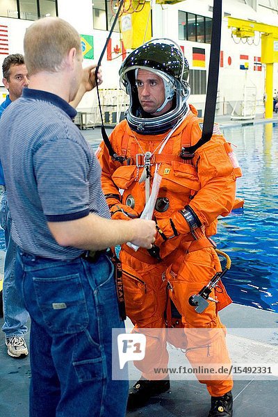 Crew trainer Bob Behrendsen briefs astronaut William A. Oefelein,  STS-116 pilot,  in the usage of parachute gear during an emergency egress training session in the Neutral Buoyancy Laboratory (NBL) near Johnson Space Center. Oefelein is wearing a training version of the shuttle launch and entry suit.