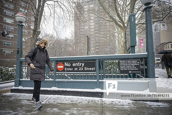 A woman leaves the subway in the Chelsea neighborhood of New York in the snow on Wednesday February 20 2019. A winter weather advisory is in effect as the snow transitions to a mix of sleet and rain and finally all rain by 1AM Thursday depositing 2-4 inches. (© Richard B. Levine).
