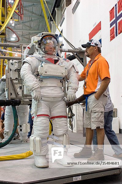 NASA astronauts Mike Fossum and Ron Garan (partially obscured) both STS-124 mission specialists are about to be submerged in the waters of the Neutral Buoyancy Laboratory (NBL) near Johnson Space Center. Fossum and Garan are attired in training versions of their Extravehicular Mobility Unit (EMU) spacesuits. Divers (out of frame) are in the water to assist the crewmembers in their rehearsal intended to help prepare them for work on the exterior of the International Space Station.
