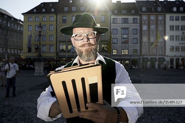Bavarian man in traditional costume using modern tablet computer in Munich Germany.