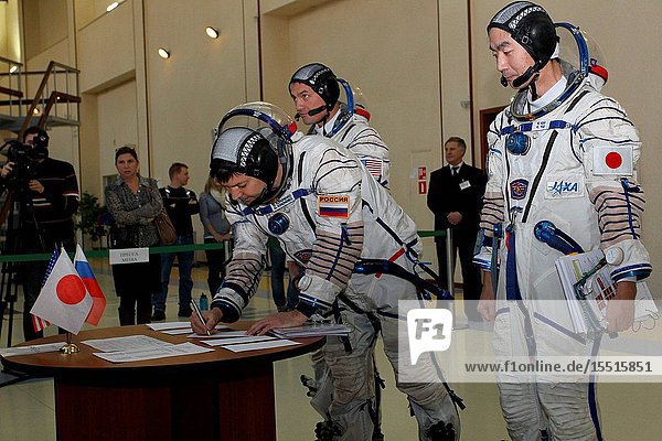 At the Gagarin Cosmonaut Training Center in Star City Russia Expedition 4243 backup Soyuz Commander Oleg Kononenko of Roscosmos signs in for the first of two days of qualification exams October 30 as his crewmates Kjell Lindgren of NASA (left) and Kimiya Yui of the Japan Aerospace Exploration Agency look on. They are the backups to the prime crew