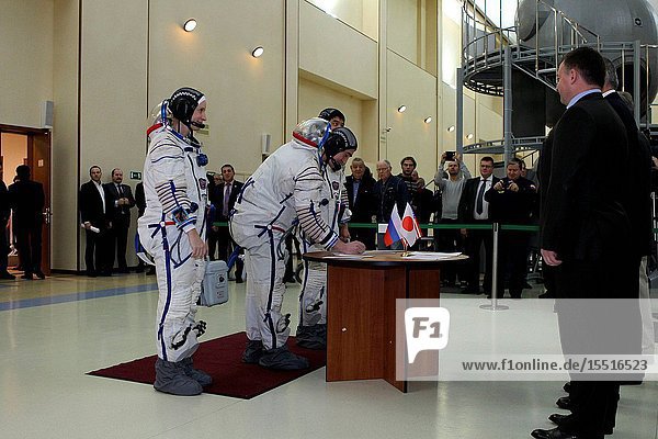 At the Gagarin Cosmonaut Training Center in Star City Russia Expedition 46-47 backup crewmember Anatoly Ivanishin of the Russian Federal Space Agency (Roscosmos) signs in Nov. 19 for the start of qualification exams as his crewmates Kate Rubins of NASA (left) and Takuya Onishi of the Japan Aerospace Exploration Agency (right behind Ivanishin) look on. They are the backups to the prime crewmembers Yuri Malenchenko of Roscosmos Tim Kopra of NASA and Tim Peake of the European Space Agency who will launch Dec. 15 in the Soyuz TMA-19M spacecraft from the Baikonur Cosmodrome in Kazakhstan for a six-month mission on the International Space Station.