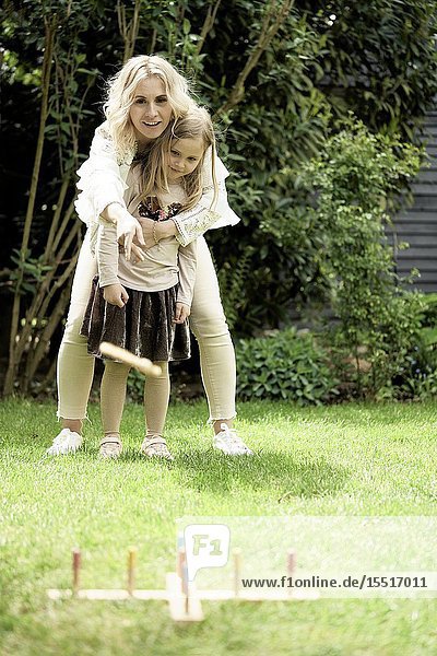 Mother and daughter playing game in garden.