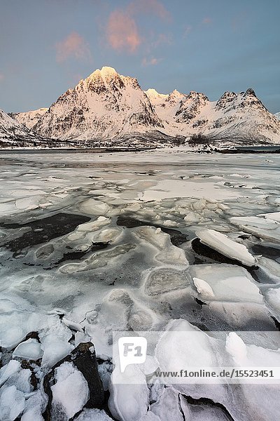 Last ray of sunshine in a winter sunset Austnesfjorden Lofoten island Northern Norway Europe.