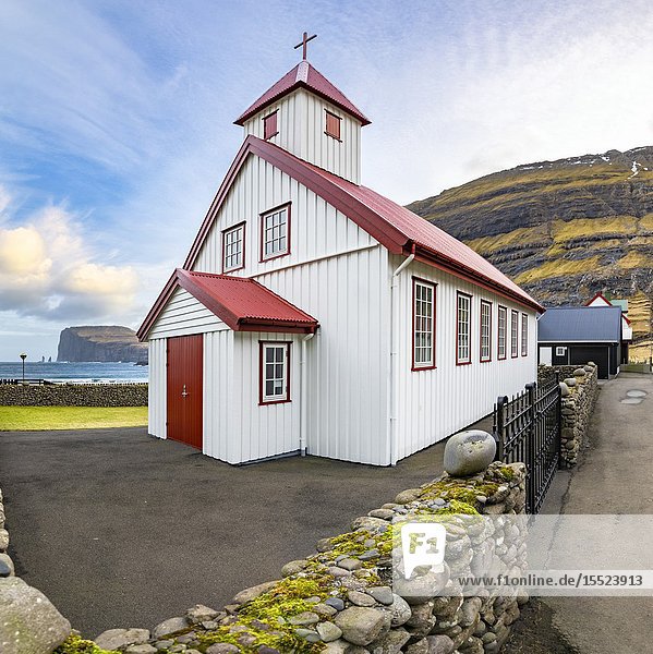 Tjornuvik Church and in background near the cliff the two sea stacks of Risin and Kellingin (Tjornuvik  Streymoy island  Faroe Islands  Denmark).