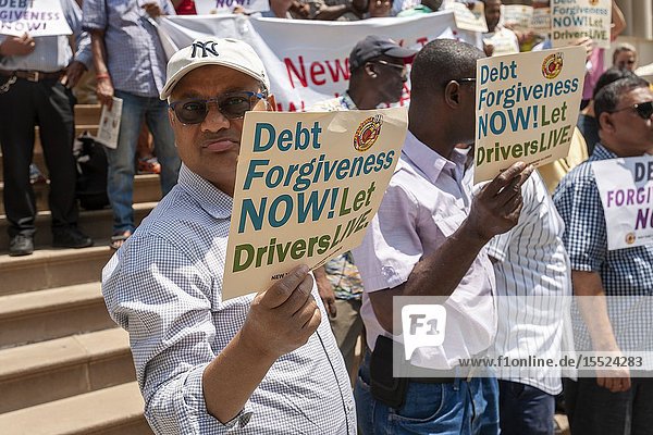 New York taxi drivers and their supporters rally on the steps of NY City Hall in Thursday July 11 2019 for a news conference calling for debt forgiveness for their medallion loans. Medallion brokers allegedly took advantage of drivers who bought medallions at artificially inflated prices and ended up burdened with debt. A number of drivers have filed for bankruptcy or are considering it and there have been a few suicides amongst stressed drivers. (© Richard B. Levine).