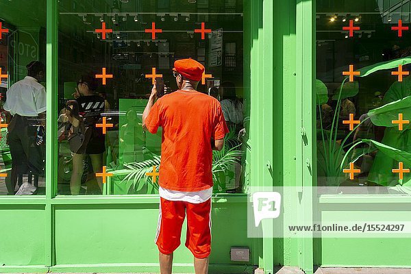 Appealing to millennials a Louis Vuitton pop-up attracts crowds willing to wait on line to enter in the heart of New York's hip Lower East Side neighborhood seen on Saturday July 13 2019. The space is covered both inside and out in a color normally reserved for television green screens and highlights selections from their artistic director Virgil Abloh's new collection. (© Richard B. Levine).