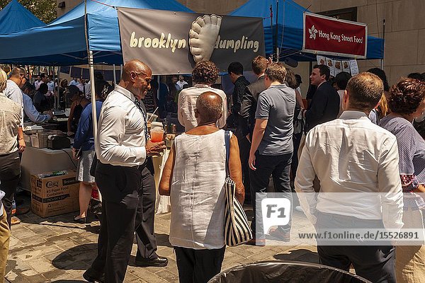 Tourists and office workers flock to Brooklyn Dumpling in The Outpost of the Queens Night Market located in Rockefeller Plaza in New York on Tuesday July 30 2019. The marketplace features ethnic and artisanal foods by small entrepreneurs all of whom are regulars at the Queens Night Market. Nine vendors will encamp in the plaza Monday through Thursday for three weeks. (© Richard B. Levine).