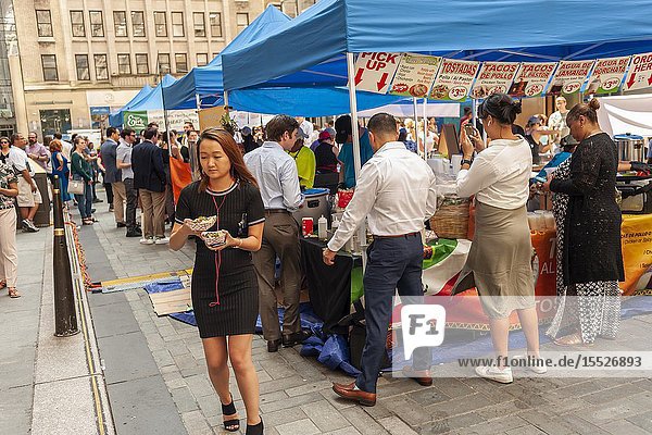 Tourists and office workers flock to The Outpost of the Queens Night Market located in Rockefeller Plaza in New York on Tuesday July 30 2019. The marketplace features ethnic and artisanal foods by small entrepreneurs all of whom are regulars at the Queens Night Market. Nine vendors will encamp in the plaza Monday through Thursday for three weeks. (© Richard B. Levine).