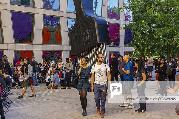 Crowds around Hank Willis Thomasâ.â. œAll Power to All Peopleâ.in the plaza of the Africa Center on Fifth Avenue at the edge of Harlem during the Museum Mile festival on Tuesday June 11 2019. (© Richard B. Levine).