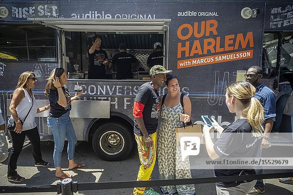 Celebrity Chef Marcus Samuelsson greets visitors to the Audible food truck serving samples of his dishes in Union Square in New York on Thursday June 27 2019. Samuelsson voices Audibleâ.s audiobook adaptation â. œOur Harlemâ. of his Red Rooster Cookbook adding interviews. (© Richard B. Levine).
