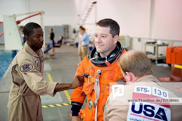 Astronaut Nicholas Patrick  STS-130 mission specialist  gets help with the donning of a training version of his shuttle launch and entry suit in preparation for a water survival training session in the waters of the Neutral Buoyancy Laboratory (NBL) near NASA's Johnson Space Center.