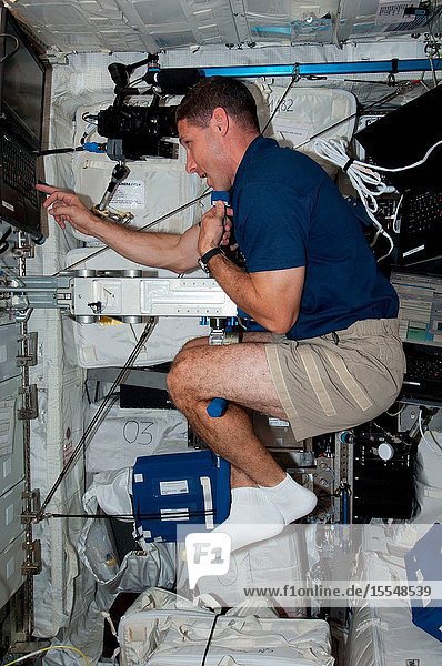 NASA astronaut Michael Hopkins Expedition 37 flight engineer performs Body Mass Measurement activities using the Space Linear Acceleration Mass Measurement Device (SLAMMD) in the Columbus laboratory aboard the Earth-orbiting International Space Station.