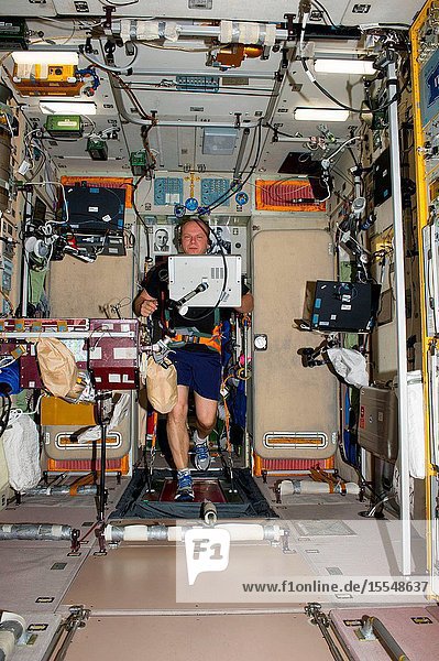 Russian cosmonaut Oleg Kotov Expedition 37 flight engineer equipped with a bungee harness exercises on the Treadmill Vibration Isolation System (TVIS) in the Zvezda Service Module of the International Space Station.