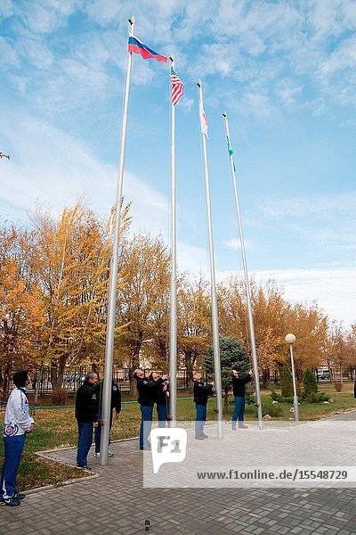 Outside their Cosmonaut Hotel crew quarters in Baikonur Kazakhstan the Expedition 3839 prime and backup crew members participate in the traditional flag-raising ceremony Oct. 27 as they conduct final pre-launch preparations. From left to right prime Soyuz Commander Mikhail Tyurin and backup Max Suraev raise the Russian flag prime Flight Engineer Rick Mastracchio of NASA and backup Reid Wiseman of NASA raise the U.S. flag prime Flight Engineer Koichi Wakata of the Japan Aerospace Exploration Agency raises the Japanese flag and backup Flight Engineer Alexander Gerst of the European Space Agency raises the flag of Kazakhstan. Wakata Tyurin and Mastracchio are scheduled to launch Nov. 7 Kazakh time in the Soyuz TMA-11M spacecraft from Baikonur to begin a six-month mission on the International Space Station.Victor Zelentsov