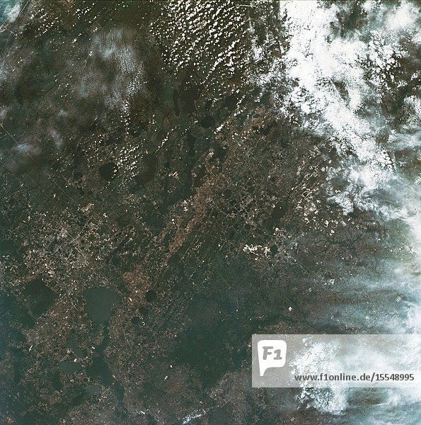 A vertical view of the Orlando and central Florida area photographed from the Skylab space station in Earth orbit. (The picture should be held with the heaviest cloud cover at the bottom.) The extensive road and highway network in the area is clearly visible. The Lakeland and Winter Haven area is near the center of the picture. Interstate 4 extends southwesterly out of Orlando through the center of the picture. The urban growth caused by the opening of the Disney World amusement complex is clearly evident. The giant recreational facility is just southwest of Orlando. This picture was taken by one of the six lenses of the Itek-furnished S190-A Multispectral Photographic Facility Experiment in the Multiple Docking Adapter of the space station. Type SO-356 film was used.