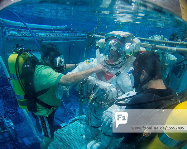 A fisheye lens was used to capture this image of NASA astronaut Barry Wilmore Expedition 41 flight engineer and Expedition 42 commander attired in a training version of his Extravehicular Mobility Unit (EMU) spacesuit as he is submerged in the waters of the Neutral Buoyancy Laboratory (NBL) near NASA's Johnson Space Center. Divers are in the water to assist Wilmore in his rehearsal which is intended to help prepare him for possible work on the exterior of the International Space Station.