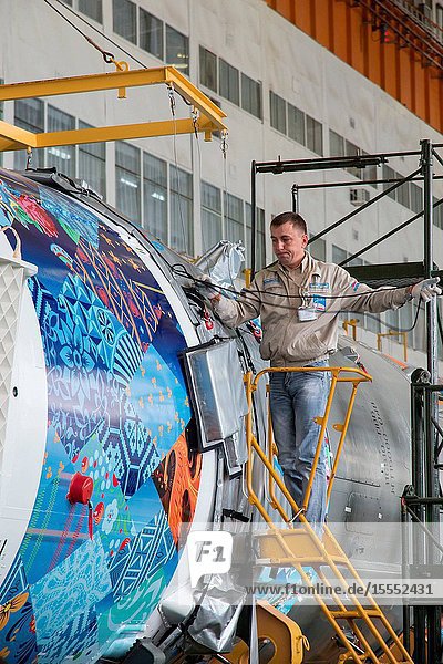 Workers make final preparations to a Soyuz TMA-11M spacecraft on Nov. 4 2013 at the Baikonur Cosmodrome in Baikonur Kazakhstan. The rocket is adorned with the logo of the Sochi Olympic Organizing Committee and other related artwork to commemorate the launch of the Olympic torch with the crew for a four-day visit to the station. The torch will return to Earth with another trio of station residents on Nov. 11 and will be part of the torch relay that ends with the lighting of the flame at the Fisht Stadium in Sochi Russia Feb. 7 to mark the opening of the 2014 Winter Olympics.Victor Zelentsov