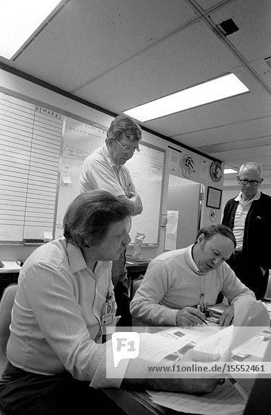 Mission evaluation room (MER) team members discuss 51-L in the Johnson Space Center's engineering office facility. Left to right are Charles Walsh Larry Meyers David Camp and Travis Libby.