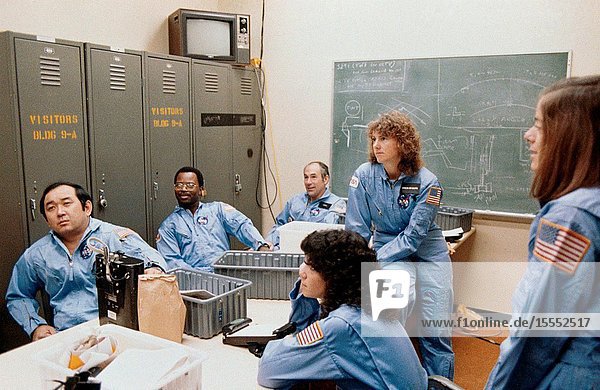 Five members of the prime crew for NASA's STS-51L mission and a backup crew member are briefed during a training session in the Johnson Space Center's (JSC) Shuttle Mock-up and Integration Laboratory. From left to right are astronaut Ellison S. Onizuka mission specialist Ronald E. McNair mission specialist Gregory D. Jarvis Hughes payload specialist Judith A. Resnik mission specialist Sharon Christa McAuliffe citizen observerpayload specialist representing the Teacher-in-Space Project and Barbara R. Morgan backup payload specialist. The photograph was taken by Keith Meyers of the New York Times.