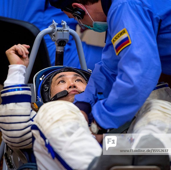 Expedition 38 Flight Engineer Koichi Wakata of the Japan Aerospace Exploration Agency is seen through glass as he and fellow crew mates Soyuz Commander Mikhail Tyurin of Roscosmos and Flight Engineer Rick Mastracchio of NASA have their Russian Sokol suits pressure checked a few hours ahead of their launch Nov. 7 2013 in Baikonur Kazakhstan. Tyurin Wakata and Mastracchio will launch in their Soyuz TMA-11M spacecraft to the International Space Station to begin a six-month mission.