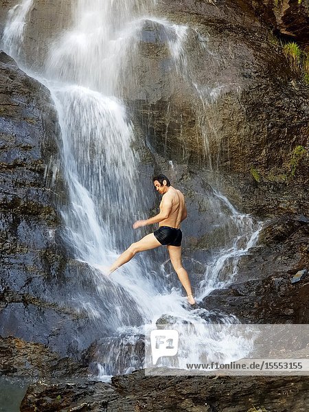 A man showering at the Mascarada waterfall Cerler Huesca Aragon Spain