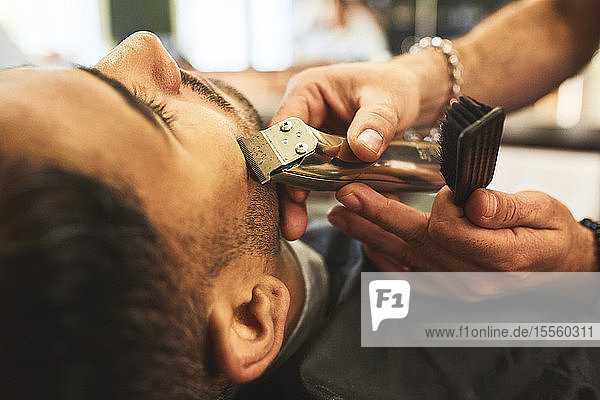 Nahaufnahme eines Mannes  der in einem Friseursalon rasiert wird