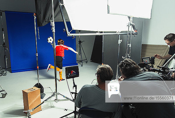 Fotografen und Teenager-Fußballspielerin im Studio Fotoshooting