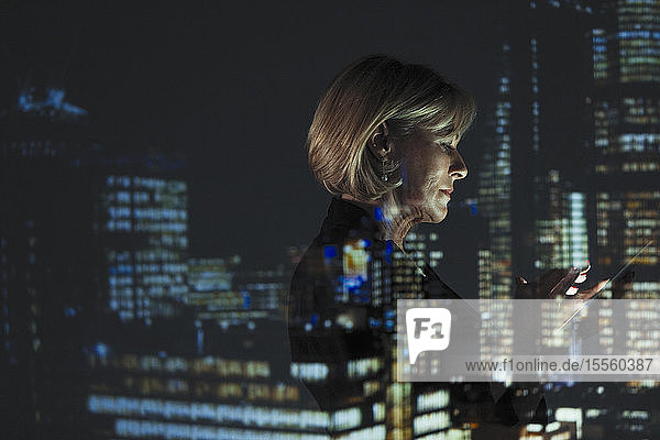 Doppelbelichtung Geschäftsfrau mit Smartphone gegen Hochhaus Lichter in der Nacht