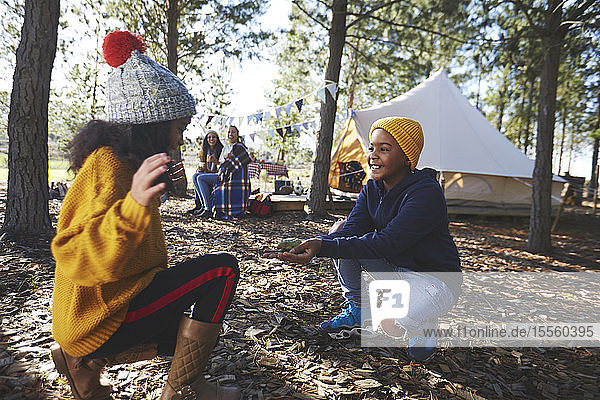 Verspielter Bruder zeigt seiner Schwester auf dem Campingplatz im Wald einen Laubfrosch