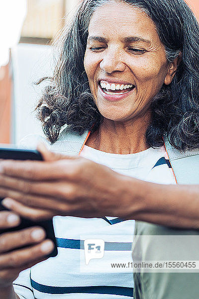 Lächelnde  glückliche Frau mit Smartphone