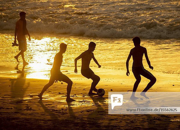 Playa de Las Canteras beach Las Palmas Gran Canaria Canary Islands Spain. Teenagers playing football at sunset on the city beach in Las Palmas on Gran Canaria.
