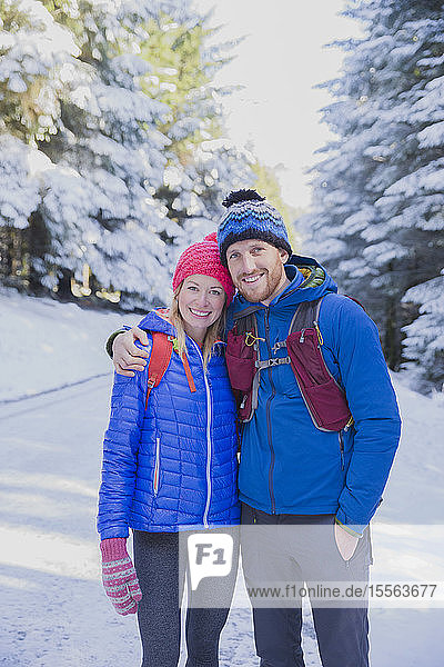 Portrait couple hiking in snow