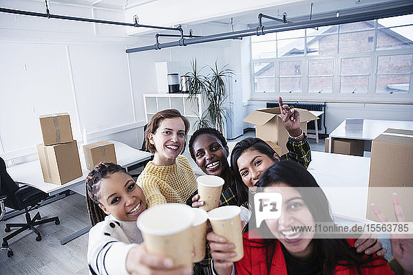 Portrait happy businesswomen celebrating new office