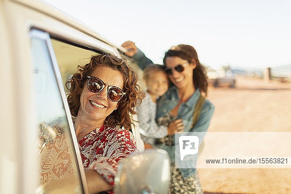Porträt glücklicher Mehrgenerationen-Frauen am Van am sonnigen Strand