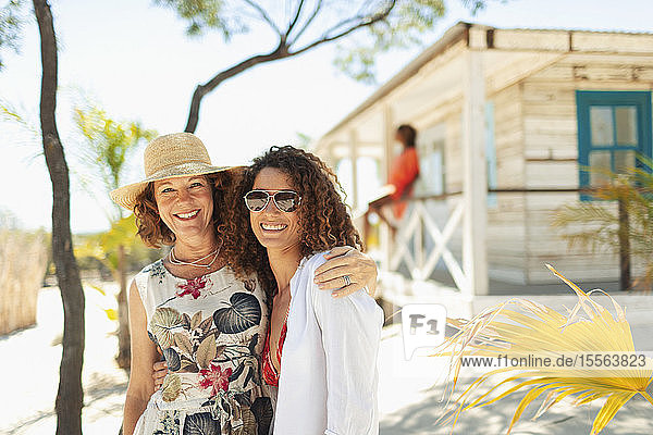 Porträt glückliche Mutter und erwachsene Tochter außerhalb sonnigen Strand Hütte