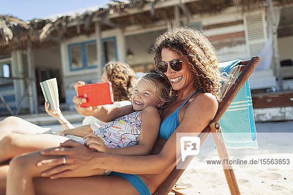 Glückliche Mutter und Tochter nehmen Selfie mit Kamera-Handy auf sonnigen Strand