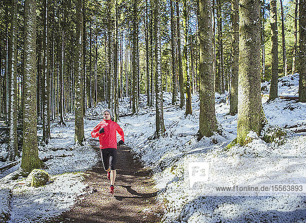 Mann joggt im verschneiten Wald