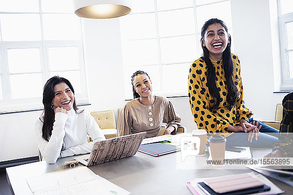 Businesswomen laughing in conference room meeting