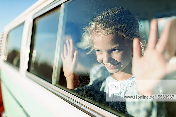 Glückliches  sorgloses Mädchen in einem sonnigen Van