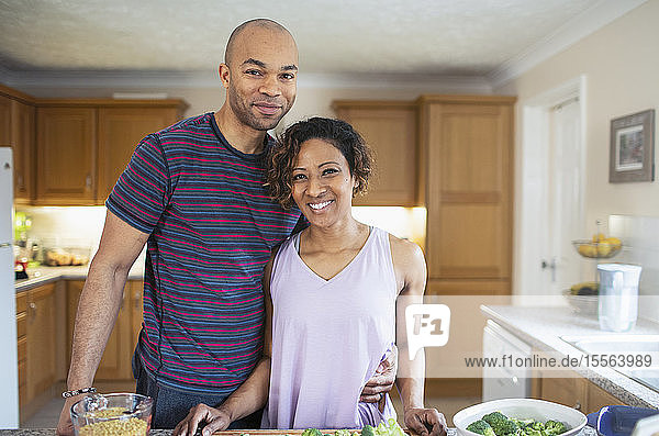 Portrait smiling couple cooking in kitchen