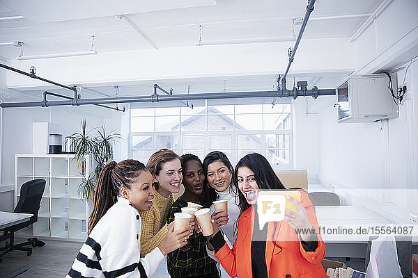 Businesswomen celebrating new office  taking selfie