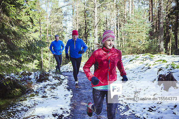 Familie joggt im verschneiten Wald